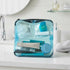 Blue DivideNPac organizer on a bathroom counter filled with travel toiletries — toothbrush, makeup, skincare, and small essentials.