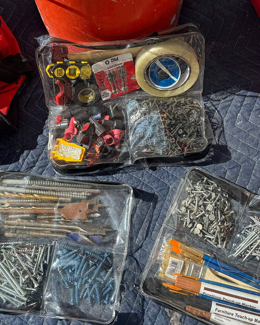 Three DivideNPac organizers packed with contractor supplies — tape measure, drill bits, screws, nails, and electrical fittings.