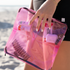 Pink DivideNPac organizer at the beach showing makeup brushes, sunscreen, and beauty essentials in separated compartments.